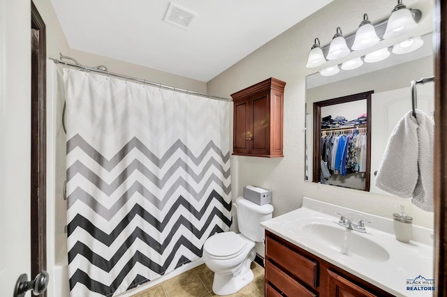 bathroom with walk in shower, vanity, toilet, and tile patterned floors