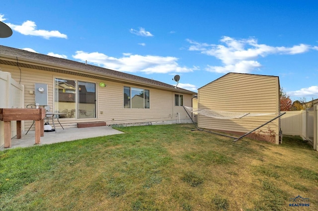 rear view of house with a patio area and a lawn