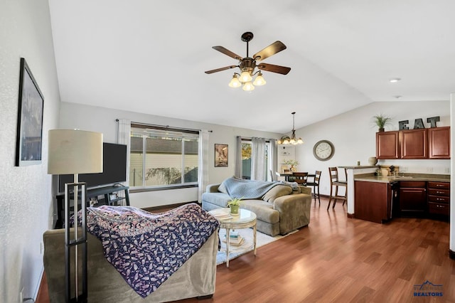 living room featuring lofted ceiling, dark wood-type flooring, and ceiling fan with notable chandelier