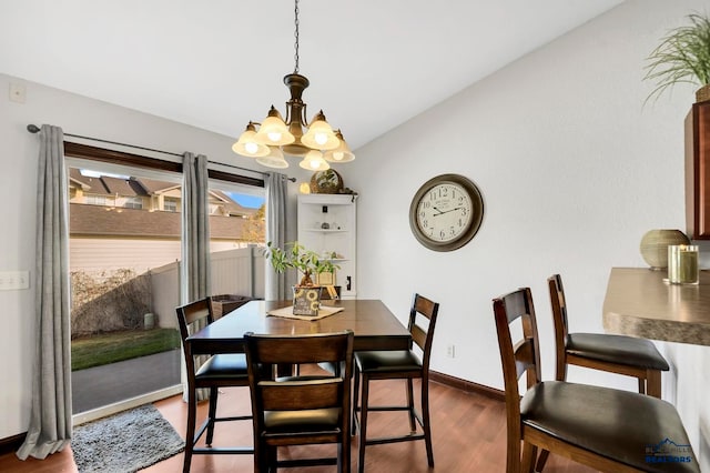 dining room featuring a chandelier, vaulted ceiling, and dark hardwood / wood-style flooring