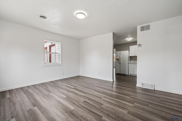 empty room featuring a textured ceiling and dark hardwood / wood-style floors