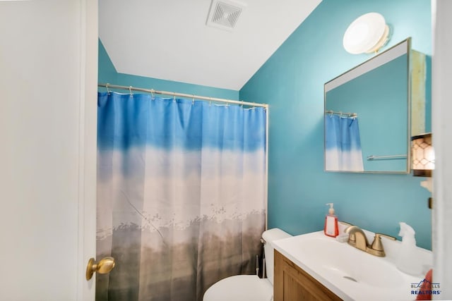 1922 Ivy Ave, Rapid City, SD 57701 - bathroom featuring vanity, toilet, vaulted ceiling, and curtained shower