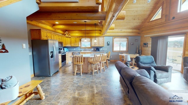 kitchen with stainless steel appliances, a breakfast bar, open floor plan, hanging light fixtures, and light countertops