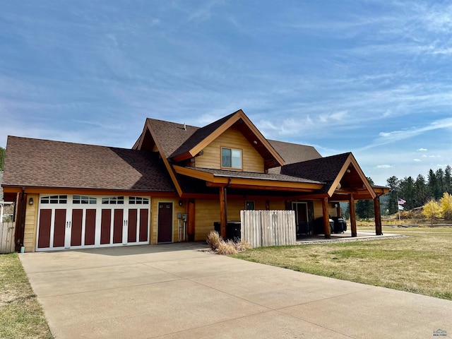 view of front of home featuring a garage, a shingled roof, a front lawn, and concrete driveway