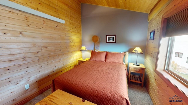 carpeted bedroom featuring vaulted ceiling, wood walls, and multiple windows