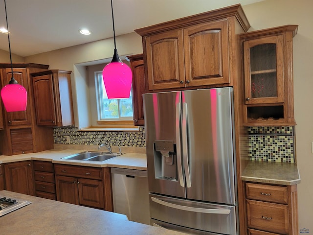 kitchen with appliances with stainless steel finishes, decorative backsplash, sink, and pendant lighting