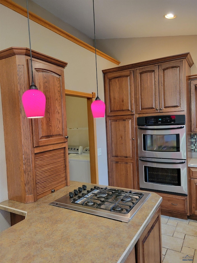 kitchen with lofted ceiling, tasteful backsplash, stainless steel appliances, washing machine and dryer, and decorative light fixtures