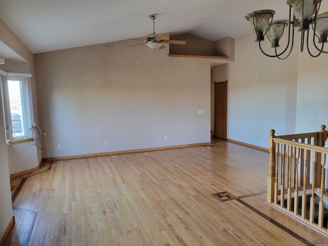 empty room featuring ceiling fan, vaulted ceiling, and light wood-type flooring