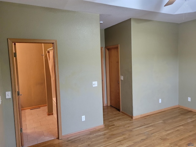 spare room with light wood-type flooring and ceiling fan