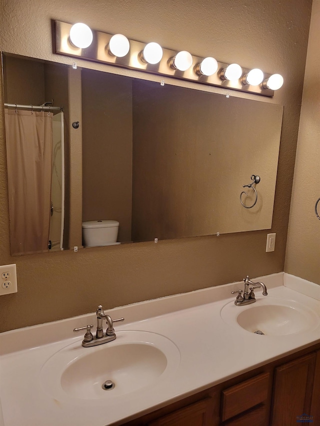 bathroom with toilet, vanity, and a shower with shower curtain