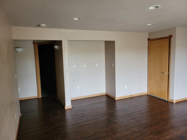 empty room with dark hardwood / wood-style flooring