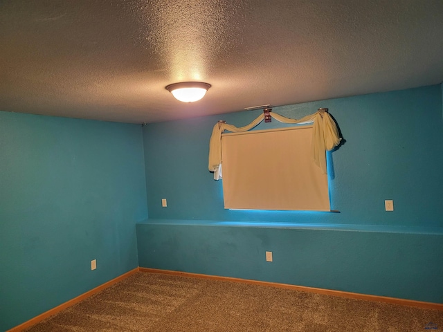 spare room with a textured ceiling and carpet flooring