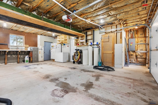 garage featuring electric panel, a garage door opener, and white fridge