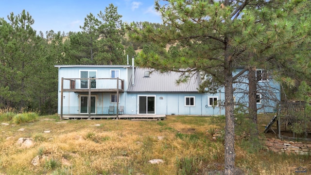 back of property with a balcony and a wooden deck