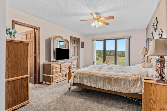 carpeted bedroom featuring ceiling fan and a textured ceiling