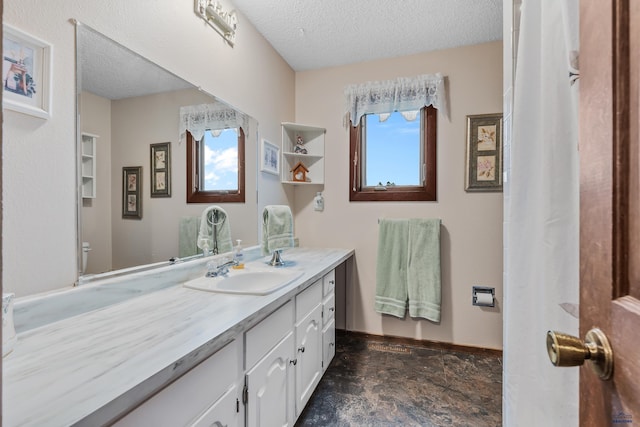 bathroom featuring vanity, a textured ceiling, toilet, and plenty of natural light