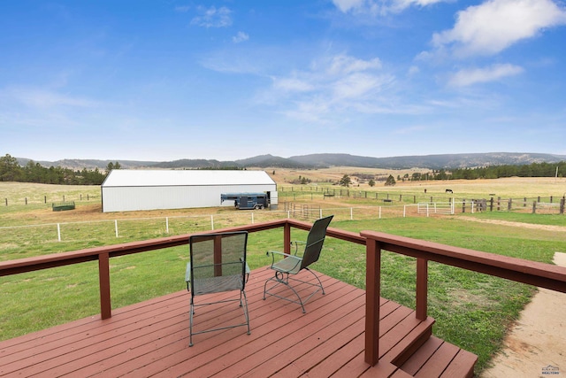 wooden deck featuring a mountain view, a lawn, and a rural view