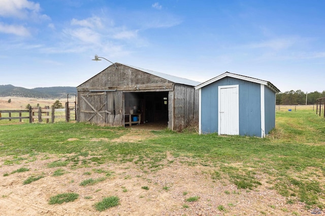 view of outdoor structure with a rural view and a yard