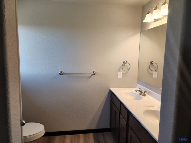 bathroom featuring vanity, hardwood / wood-style flooring, and toilet