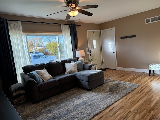 living room featuring hardwood / wood-style floors and ceiling fan