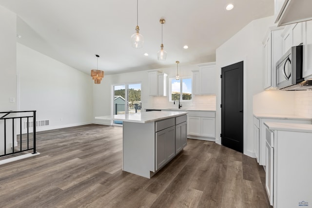 kitchen featuring pendant lighting, white cabinets, dark hardwood / wood-style floors, and a center island