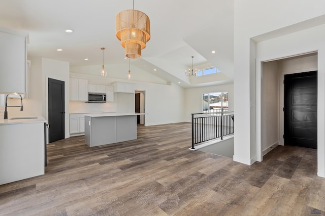 kitchen with a kitchen island, decorative light fixtures, sink, and white cabinetry