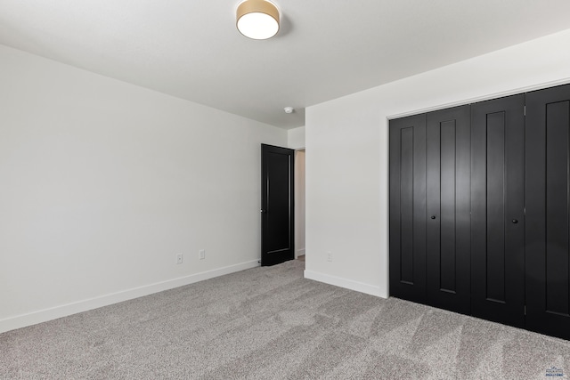 unfurnished bedroom featuring a closet and light colored carpet