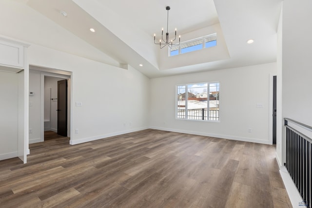 unfurnished living room with hardwood / wood-style flooring, a chandelier, and lofted ceiling