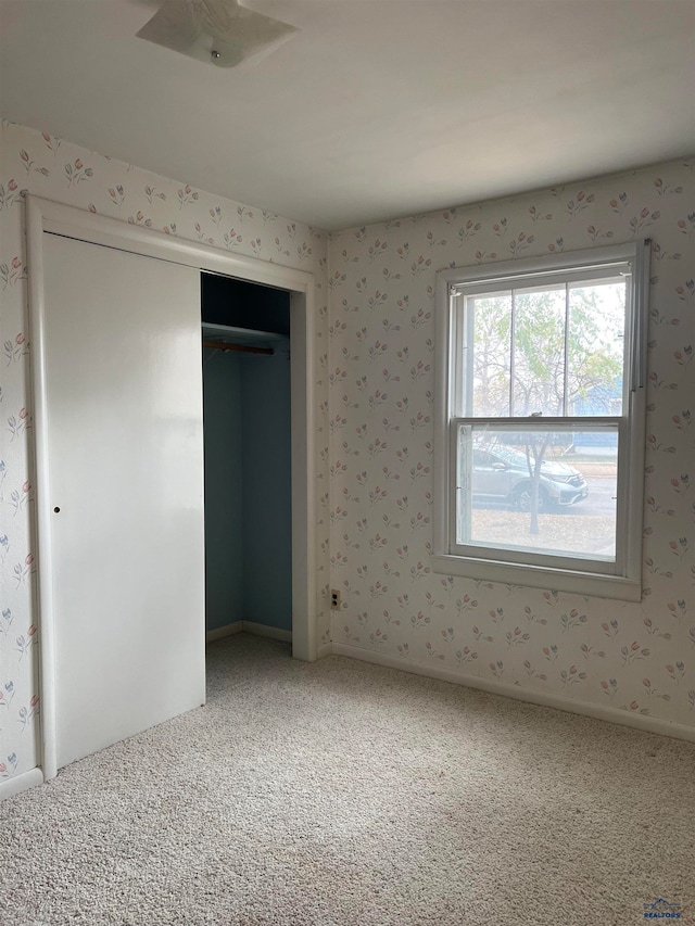 unfurnished bedroom with carpet floors and a closet