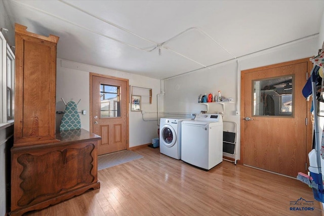 washroom featuring washing machine and clothes dryer and light hardwood / wood-style flooring