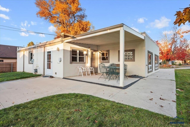 back of house with a lawn and a patio area