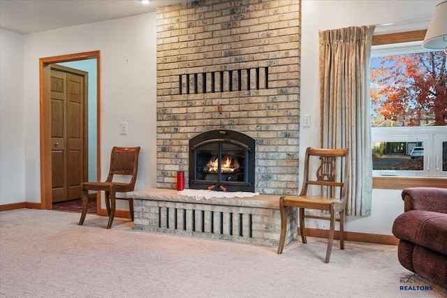 sitting room featuring a brick fireplace and carpet