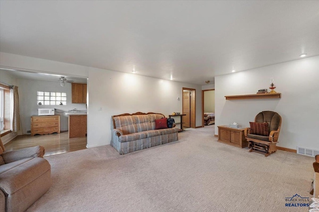 carpeted living room with ceiling fan