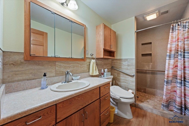 bathroom with wood-type flooring, toilet, tile walls, a shower with curtain, and vanity