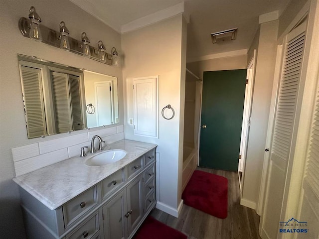 bathroom with shower / bath combination, vanity, and wood-type flooring