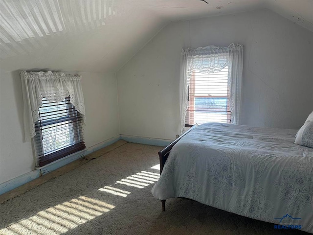 bedroom with carpet floors and vaulted ceiling