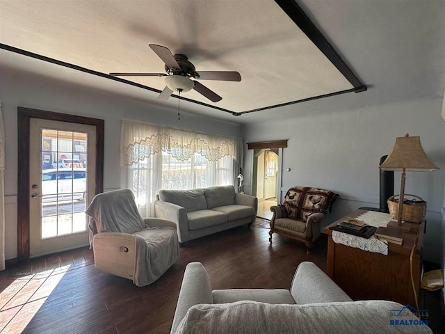 living room featuring ceiling fan and dark hardwood / wood-style floors