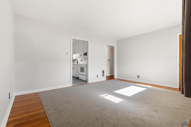 unfurnished bedroom with sink, hardwood / wood-style flooring, and ensuite bath