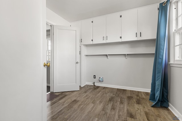 washroom featuring dark wood-type flooring, cabinets, and a healthy amount of sunlight