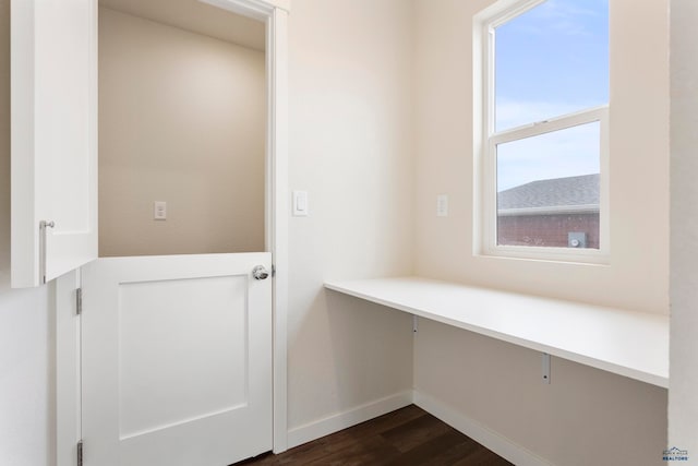 unfurnished office featuring dark wood-style floors and baseboards