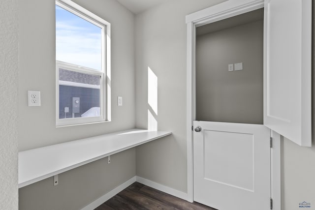 mudroom featuring dark wood-style flooring and baseboards