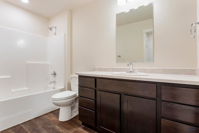 bathroom featuring shower / washtub combination, vanity, toilet, and wood finished floors