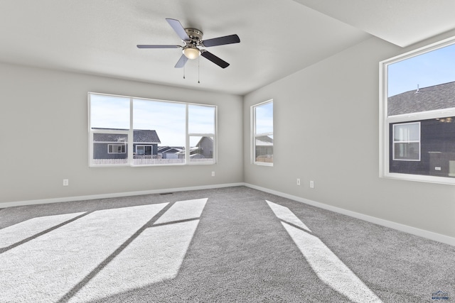 empty room with carpet floors, ceiling fan, and baseboards