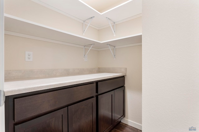 walk in closet with dark wood-type flooring