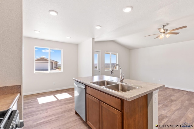 kitchen featuring sink, a healthy amount of sunlight, stainless steel dishwasher, an island with sink, and vaulted ceiling