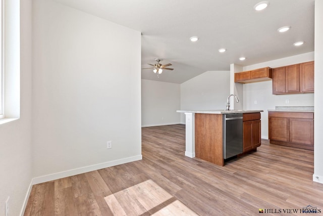 kitchen with stainless steel dishwasher, light hardwood / wood-style floors, lofted ceiling, and a kitchen island with sink