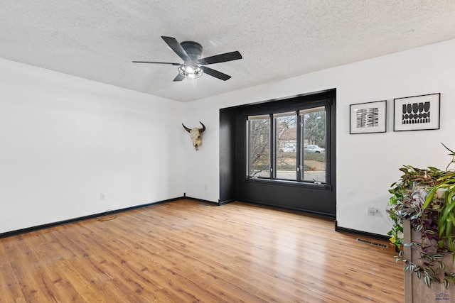 unfurnished room featuring light wood-type flooring, a textured ceiling, and ceiling fan