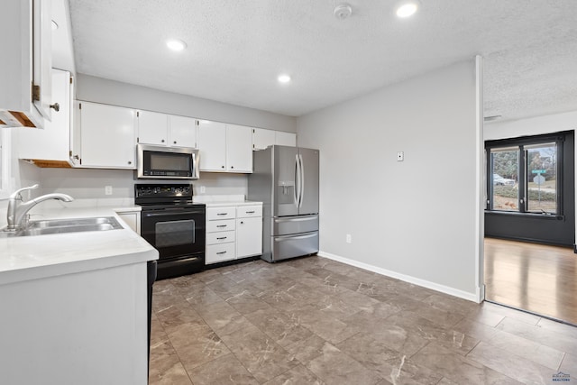 kitchen featuring white cabinetry, stainless steel appliances, a textured ceiling, and sink