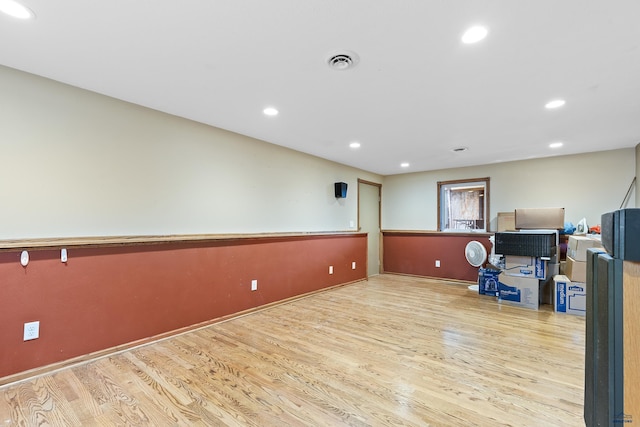 exercise room with light hardwood / wood-style floors