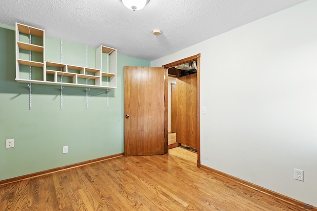 unfurnished bedroom with light hardwood / wood-style floors and a textured ceiling